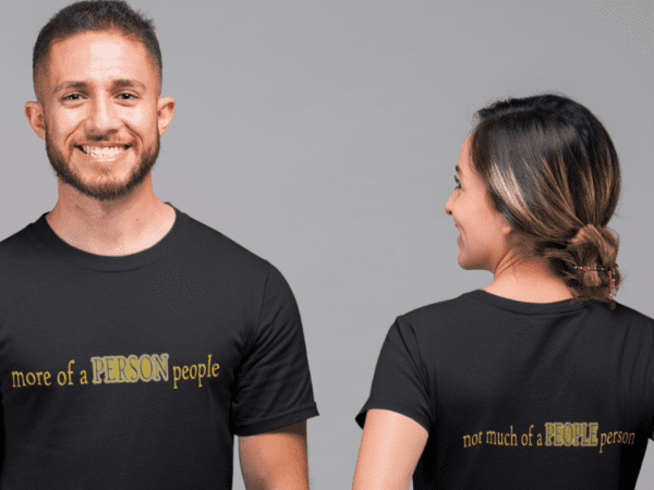 A man and woman wearing black shirts with gold lettering.