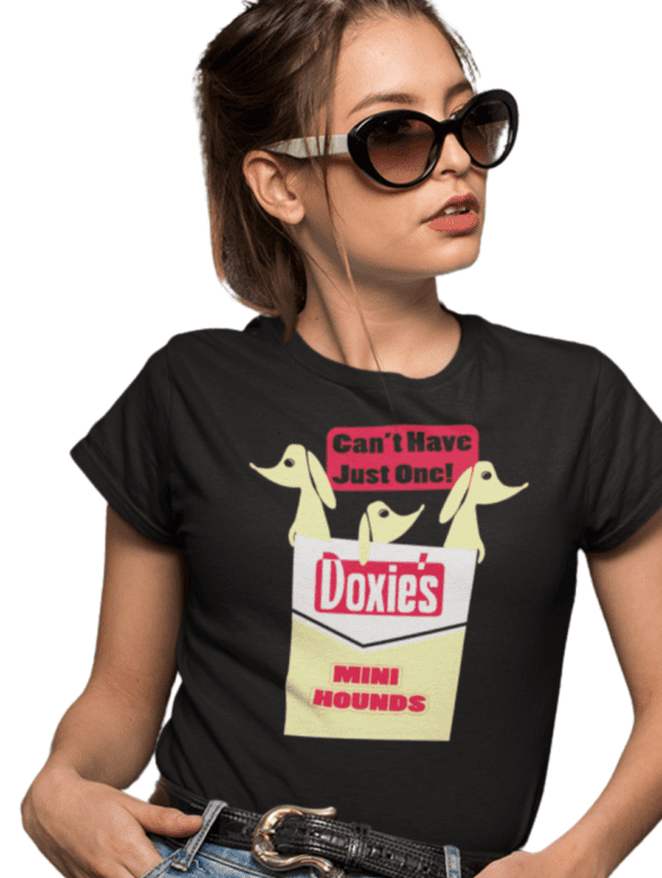 A woman wearing sunglasses and a t-shirt with the words " doxie 's mini hounds " on it.