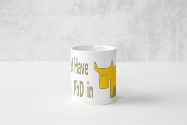 A white mug with a yellow dog and the words " i have no phd in ".