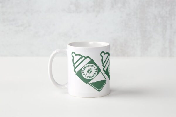 A white coffee mug with a green logo.