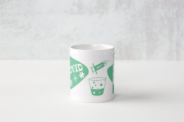 A white coffee mug with green and white designs.