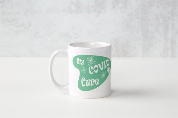 A white mug with the words " my covid cure ".