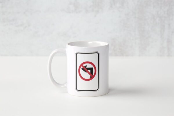 A white mug with a picture of a no left turn sign.