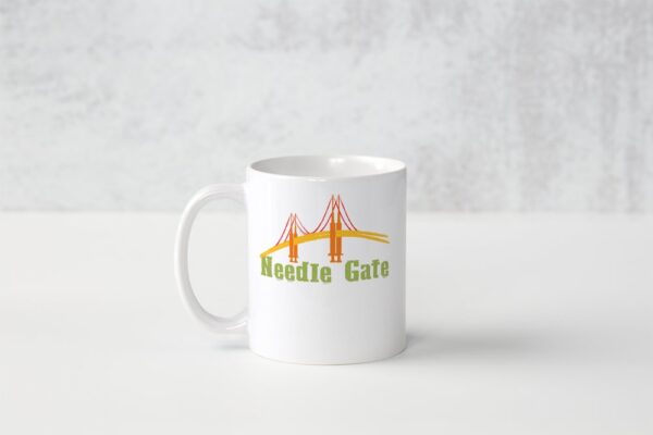 A white mug with the words needle gate on it.